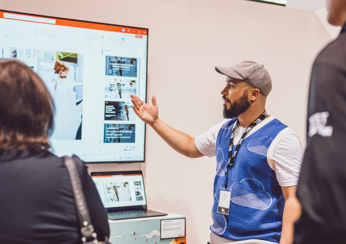 Une personne donne une présentation à un petit groupe en utilisant un grand écran et un ordinateur portable.