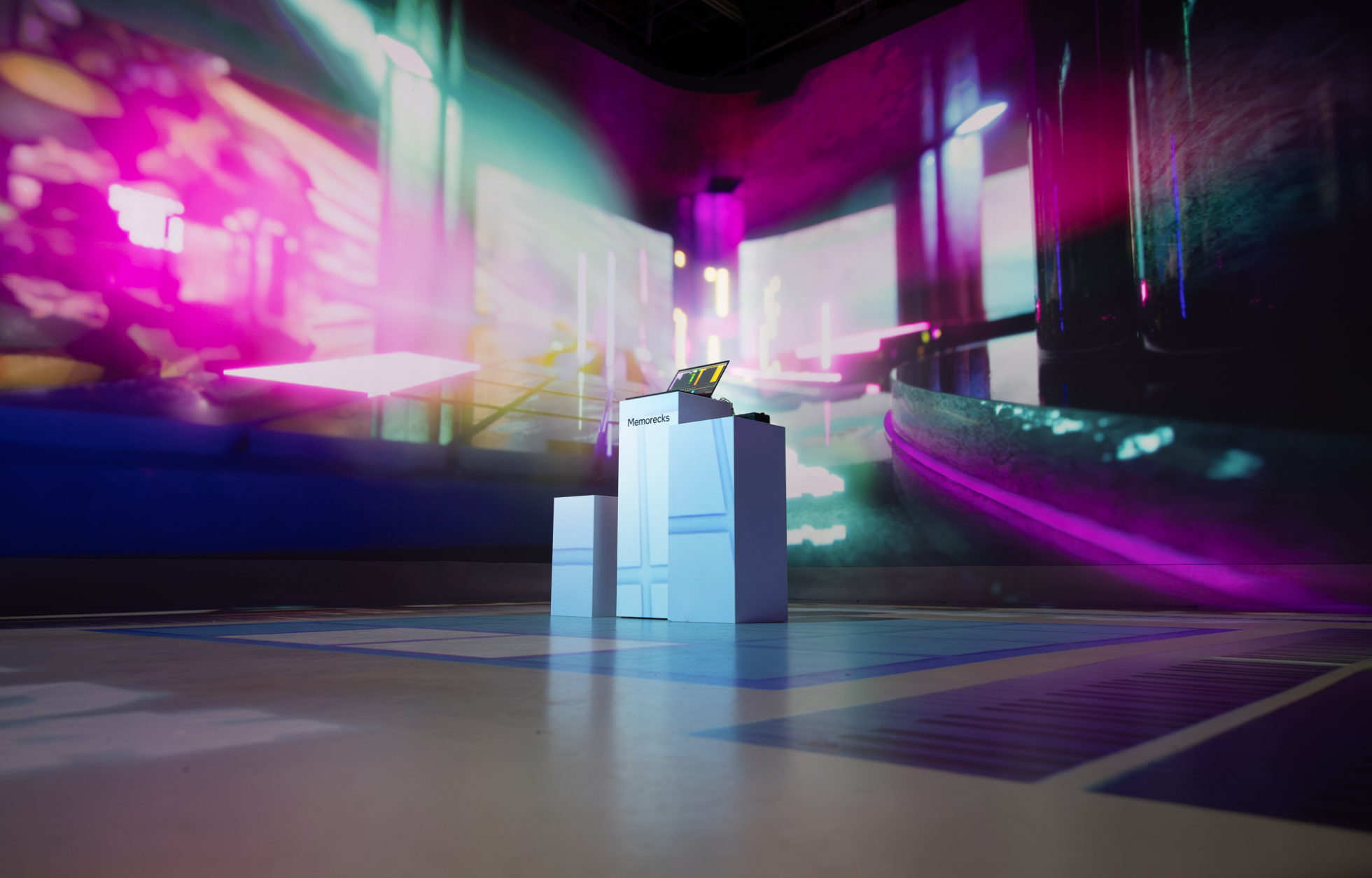 A futuristic, colorful digital art installation with a podium and vibrant lighting.