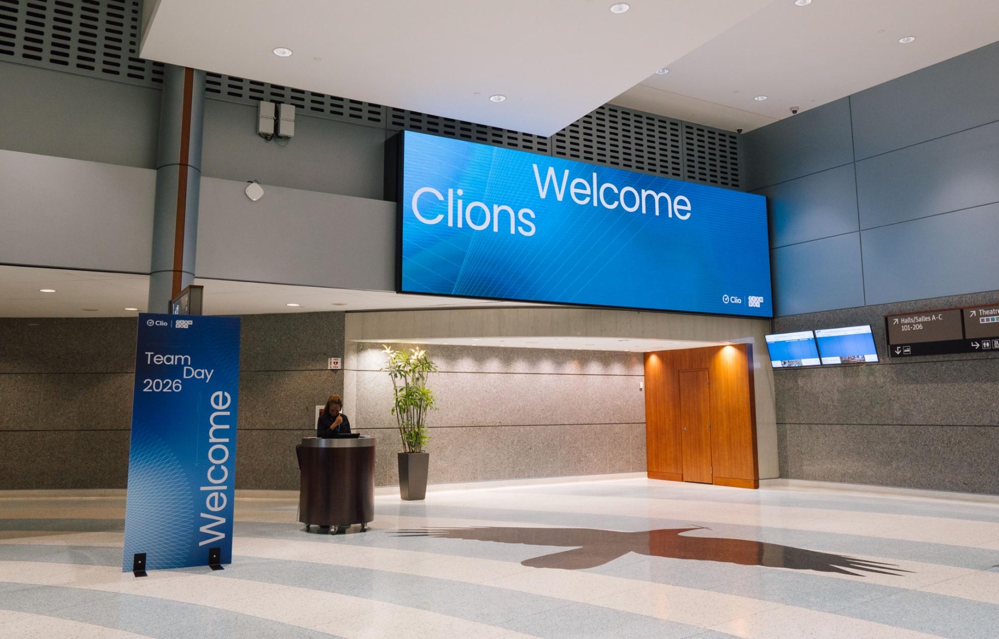 A spacious lobby with a banner that reads "Welcome Clions" and a sign that says "Team Day 2026 Welcome."
