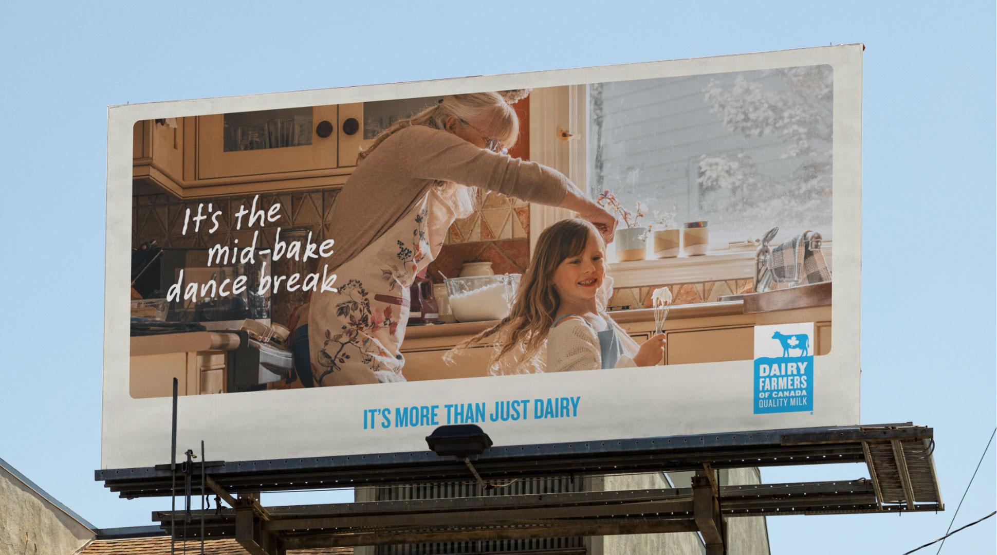 A billboard shows a child and an older woman dancing in a kitchen, with the text "It's the mid-bake dance break" and a Dairy Farmers of Canada logo.