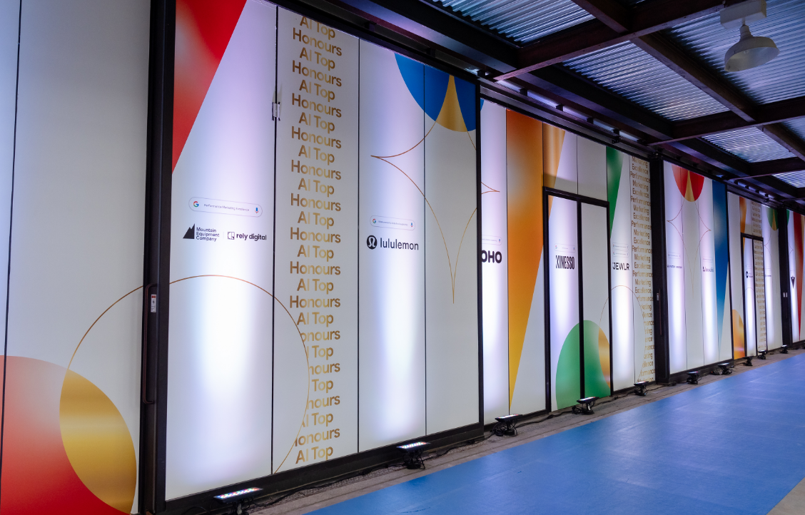 An indoor hallway with colorful geometric designs and logos on the walls.