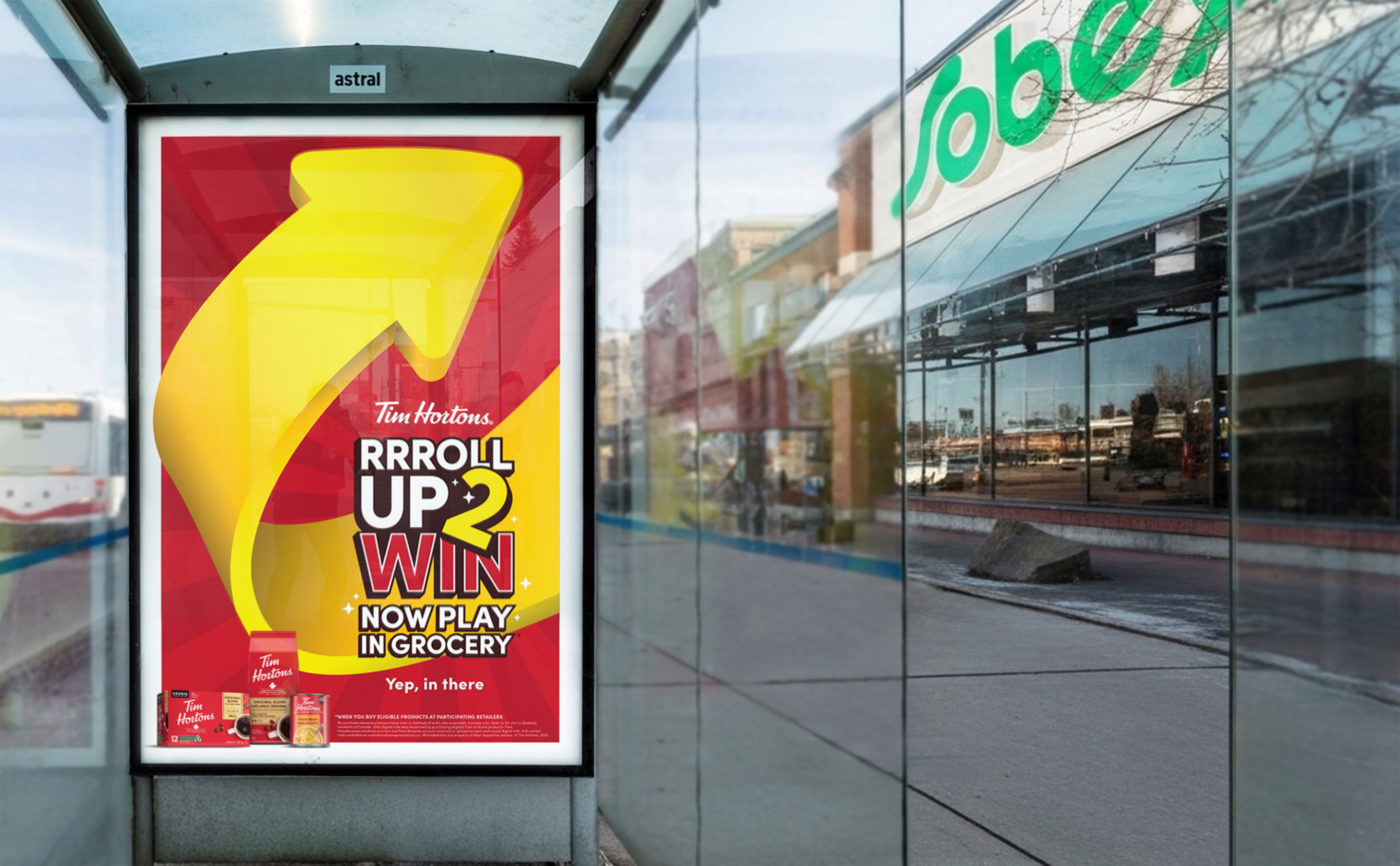 The image features a red and yellow promotional graphic for Tim Hortons' "Roll Up 2 Win" event with the text "Now Play in Grocery" and "Yep, behind you."