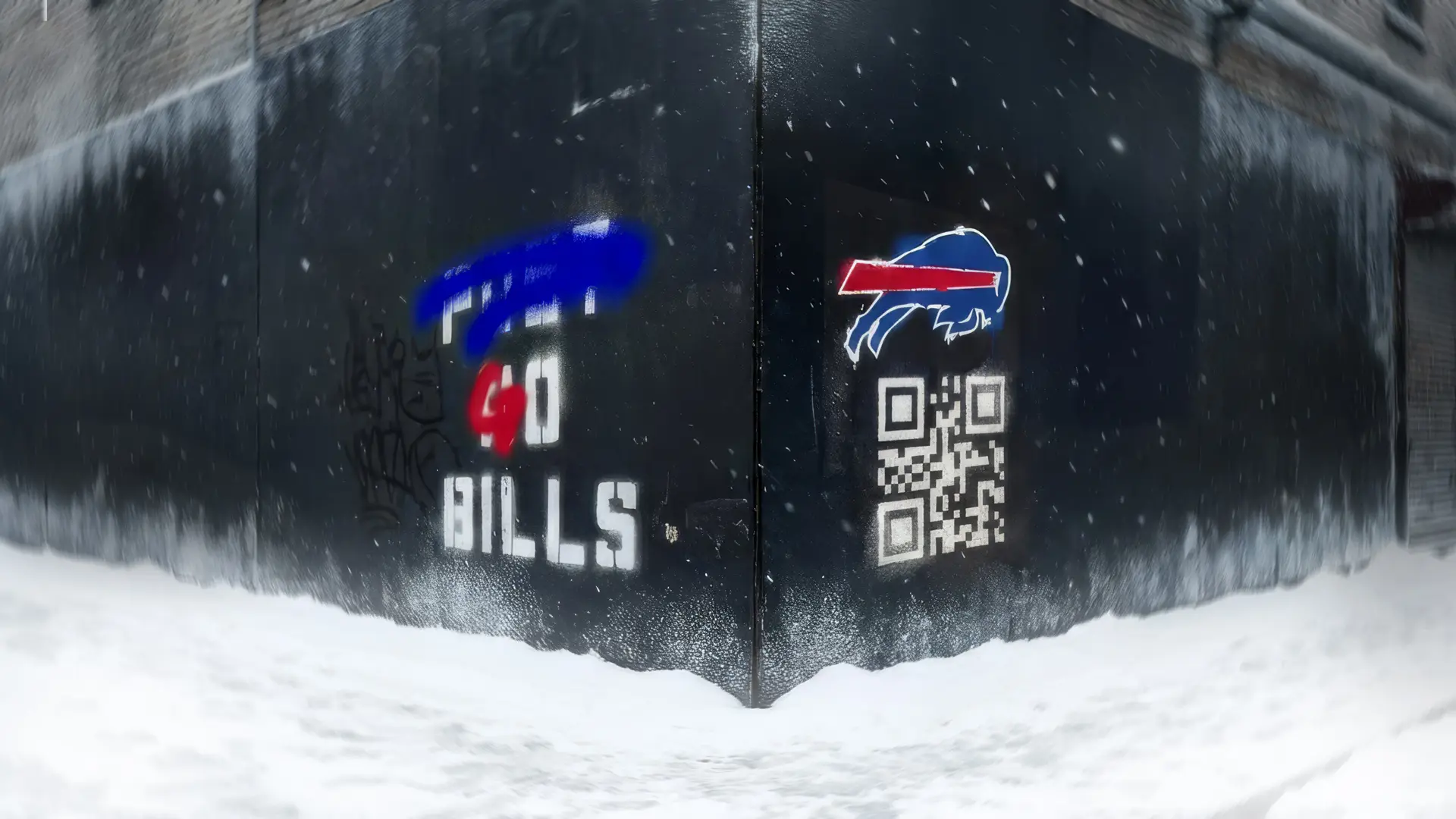 Snow covers the ground in front of a black wall with graffiti, a QR code, and a sports team logo.
