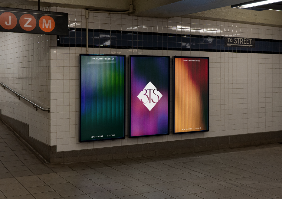 Three colorful digital posters on a subway station wall with a white diamond logo in the center.