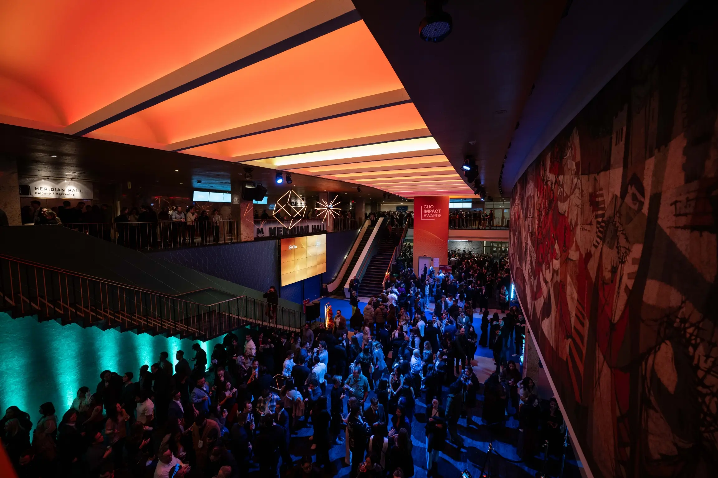 Une grande foule se rassemble dans l'intérieur vivement éclairé de Meridian Hall lors d'un événement.