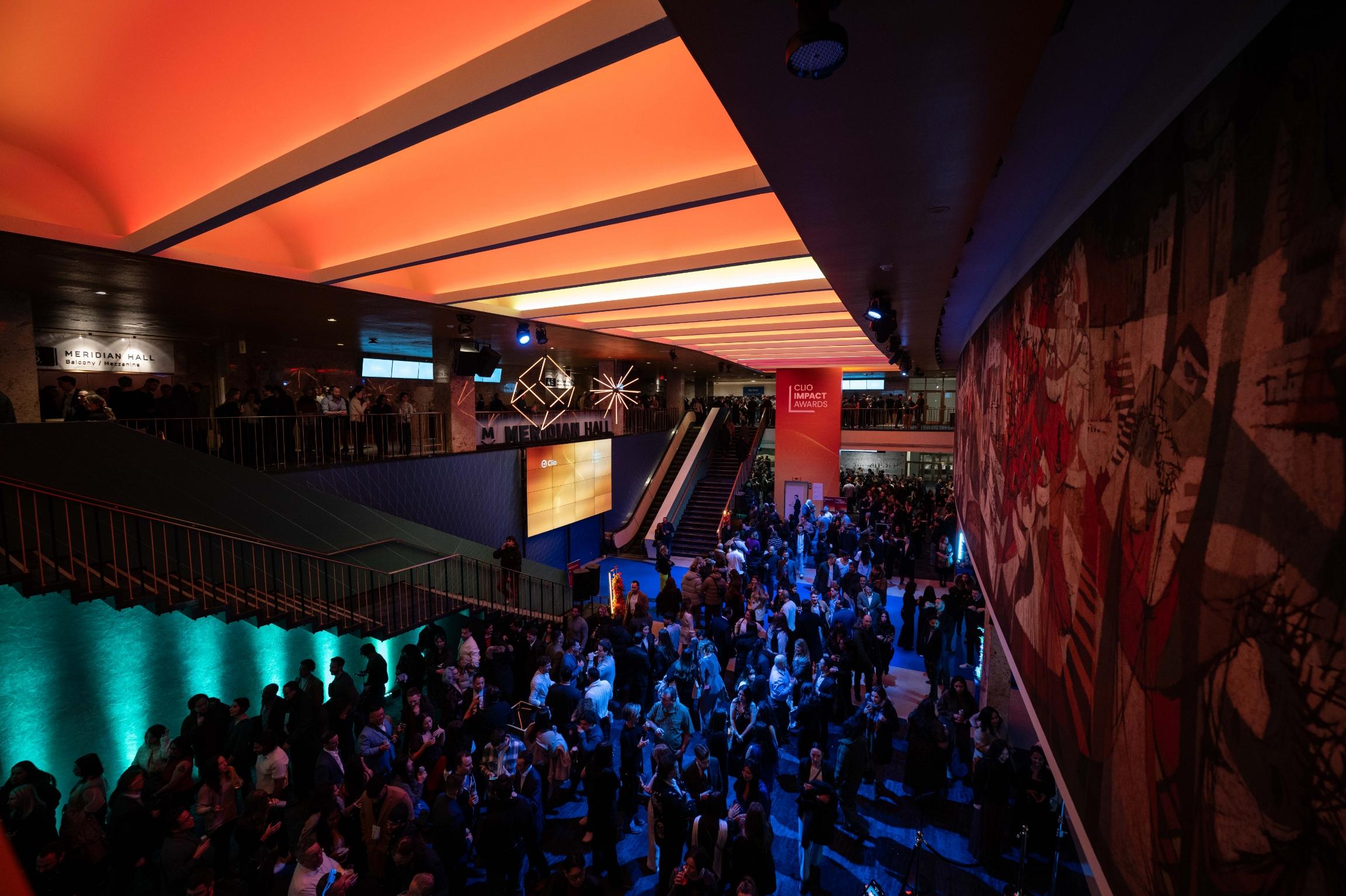 A large crowd gathers in the brightly lit interior of Meridian Hall during an event.