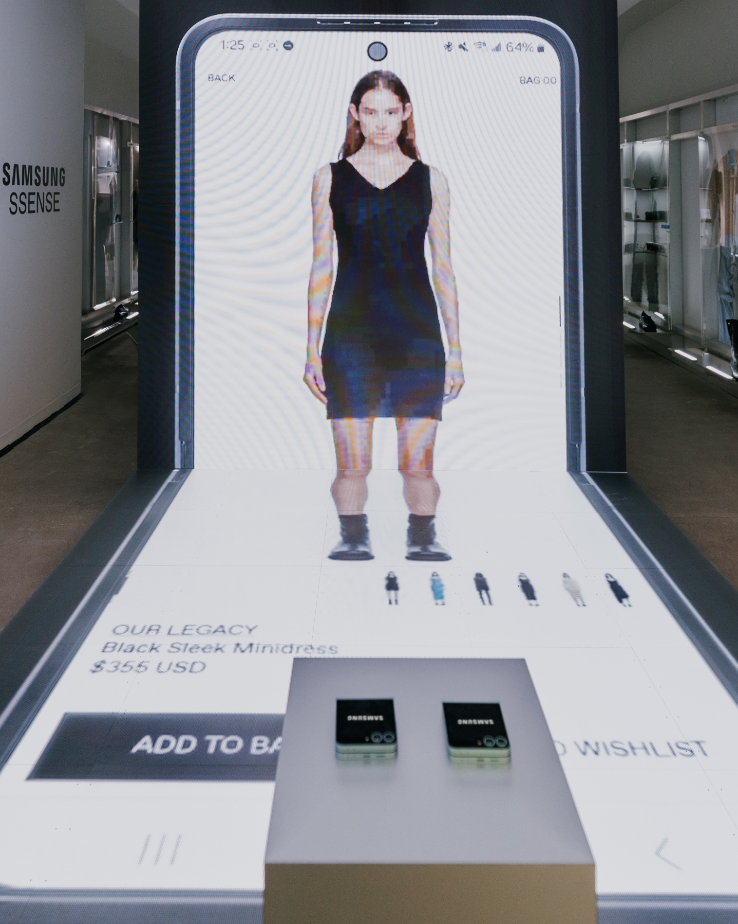 A large digital display shows a woman modeling a black minidress with shopping options below.