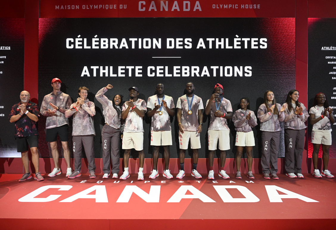 A group of athletes on stage at an event celebrating their achievements, with a background displaying "Athlete Celebrations" in English and French.