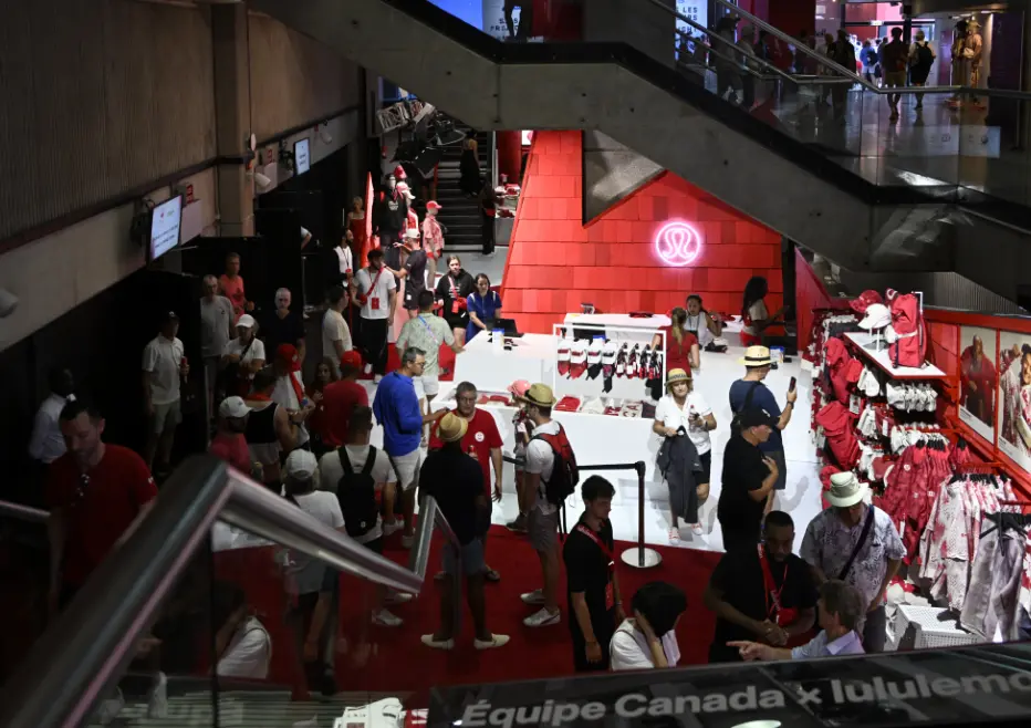 A busy store with people shopping for sports merchandise, featuring red and white apparel displayed.